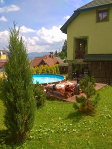 a house with a swimming pool in front of a house at Chalet Trostian in Slavske