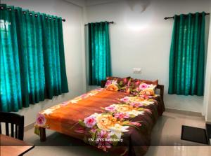 Ce lit se trouve dans un dortoir doté de rideaux verts. dans l'établissement EN Jays Residency (Service Apartments), à Kottayam