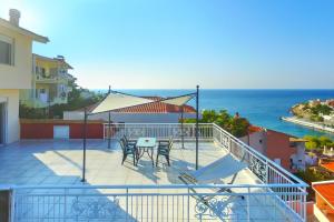 a balcony with a table and chairs and the ocean at Villa Skala Marion (Michalis) in Skala Marion