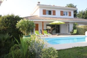 a villa with a swimming pool in front of a house at Chez Sophie in Lège-Cap-Ferret
