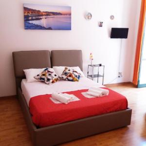 ein Bett mit zwei Kissen und einer roten Decke in der Unterkunft Affaccio Salerno in Salerno