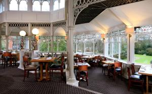 a restaurant with tables and chairs in it at Macdonald Kilhey Court Hotel & Spa in Wigan