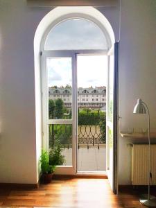 Une porte ouverte s'ouvre sur un balcon avec vue. dans l'établissement Apartamenty Sienkiewicza10, à Łomża