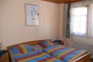 a bedroom with a bed with colorful blankets on it at Ferienwohnung Feldhege in Bacharach