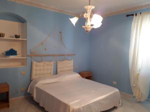 1 dormitorio con 1 cama con pared azul en Casa Stella Marina en Carbonia