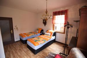 a bedroom with two beds and a chandelier at Ferienwohnung Sabine in Schmalkalden