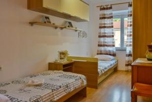 a small room with two beds and a window at Apartman Pio in Senj