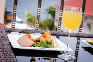 a plate of food and a glass of orange juice at Hotel Barmoi in Freetown