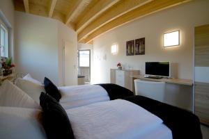 1 dormitorio con 2 camas blancas y TV en Hotel-Restaurant-Haus Berger, en Viersen