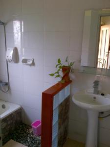 a bathroom with a sink and a mirror at Cerah Hotel in Paiton
