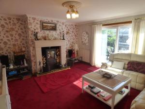 a living room with a couch and a fireplace at Fantasia in Leven-Fife