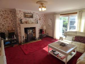 a living room with a couch and a fireplace at Fantasia in Leven