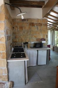 a kitchen with a stove and a stone wall at Il Borghetto Country Charme in Cefalù