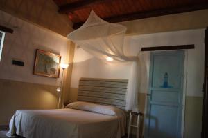 a bedroom with a bed and a lamp and a door at Il Borghetto Country Charme in Cefalù