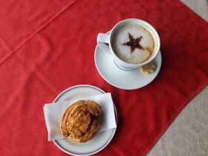 a cup of coffee and a pastry on a red table at Anno Santo Hotel in Galway