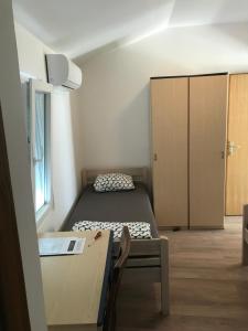 Cette petite chambre comprend un lit et une armoire. dans l'établissement Novalja Inn 2, à Novalja