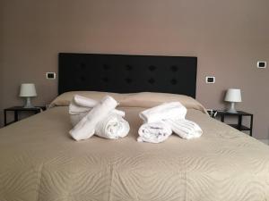 a bed with towels on it with two lamps at La Corte del Re Borbone in Caserta