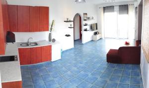 Il comprend une cuisine dotée d'un sol carrelé bleu et d'un canapé. dans l'établissement Maya Bay, à Kallithéa Halkidikis