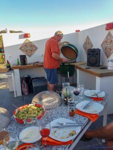 a man standing in a kitchen preparing food at Casa Lamberdina in Parroquia de la Fuensanta