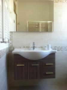 a bathroom with a white sink and a mirror at la casa per le tue vacanze in Milazzo