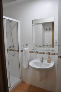 a white bathroom with a sink and a shower at Apartamento Los Jardines San Miguel in Vejer de la Frontera