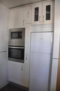 a kitchen with a refrigerator and a microwave at Apartamento Los Jardines San Miguel in Vejer de la Frontera