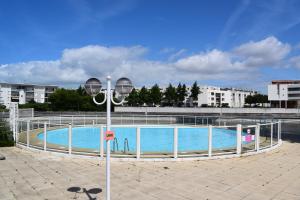 una piscina con un poste de luz al lado en Les 3M, en La Rochelle