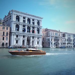 a boat in the water in front of a building at Casa Barzizza in Venice