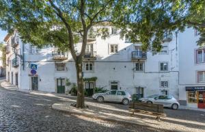リスボンにあるCasa do Casteloの建物前の木とベンチ