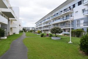 un complejo de apartamentos con un patio de césped junto a un edificio en Les 3M, en La Rochelle