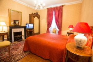 - une chambre avec un lit rouge et une télévision dans l'établissement Hotel La Villa Fleurie, à Beaune