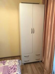 um quarto com um armário branco ao lado de uma cama em Griboedovi N.6 em Batumi