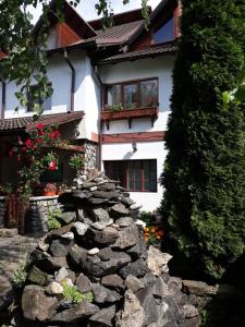 a stone wall in front of a house at Pensiunea Trei Ponei in Corbeni