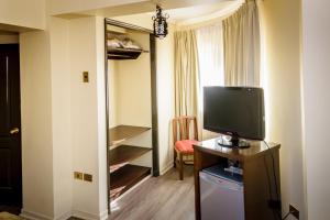 a room with a television on a table with a mirror at Hotel Diego de Almagro Antofagasta Express in Antofagasta