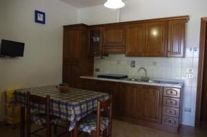 a kitchen with wooden cabinets and a table and a sink at Agriturismo Merano in Alberese