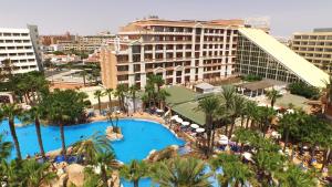 
a large swimming pool surrounded by palm trees at Playacapricho Hotel in Roquetas de Mar
