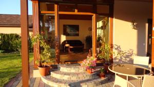 Babīte的住宿－Holiday Home Medus，一座种植了盆栽植物的庭院,房子前面设有一张桌子
