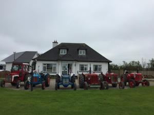 a group of tractors parked in front of a house at Padua Guest Accommodation Rosslare in Rosslare