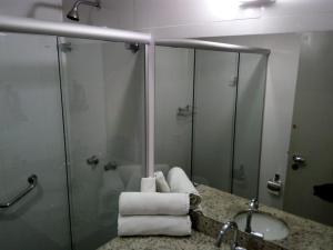 a bathroom with a sink and a shower and towels at Pipa's Bay - Flats para temporada in Pipa +12 photos