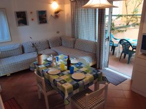 a living room with a table and a couch at Casa Gialla in Costa Paradiso