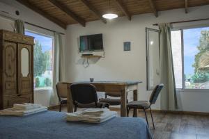 a room with two beds and a desk and a television at Las Lechuzas in Tandil