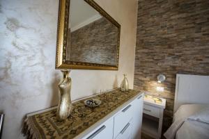 een badkamer met een wastafel en een spiegel aan de muur bij La Perla Del Tirreno in Tropea +70 foto's