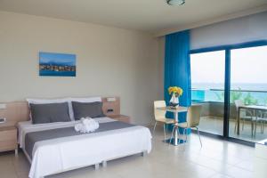 Nautilus Bay Hotel في كيساموس: غرفة نوم بها سرير وطاولة وكراسي