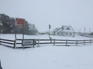 a sign in the snow next to a fence at Padua Guest Accommodation Rosslare in Rosslare