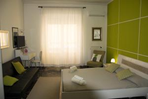 a bedroom with a bed and a couch and a window at B&B Myrta Maria in Cagliari