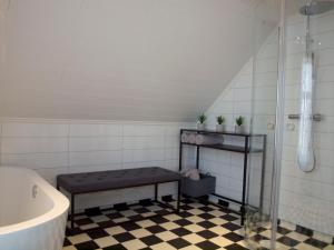 a bathroom with a tub and a bench next to a shower at Kårstua - Austrått Agroturisme in Austrått +45 photos