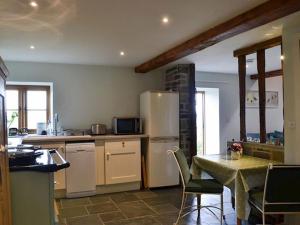 een keuken met een tafel en een koelkast bij Swallow Barn in Llanwrtyd Wells