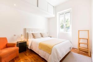 リスボンにあるAndre Vila Berta Premiumの白いベッドルーム(ベッド1台、椅子付)