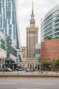 un grande edificio con una torre dell'orologio in una città di Gold Apartment Złota - Palace of Culture View- NETFLIX-Free Parking 500 meters from the apartment a Varsavia