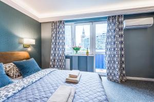 a bedroom with a bed and a large window at Gold Apartment Złota - Palace of Culture View- NETFLIX-Free Parking 500 meters from the apartment in Warsaw